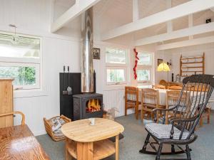 a living room with a wood stove and a table at 4 person holiday home in Præstø in Præstø