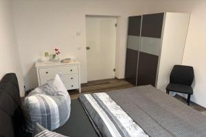 a bedroom with a bed and a dresser and a chair at Living-Apartment-mit-Kamin-und-Terrasse in Dresden