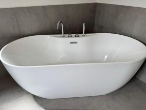 a white bath tub with a faucet in a bathroom at Living-Apartment-mit-Kamin-und-Terrasse in Dresden