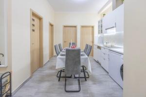 a dining room with a table and chairs in a kitchen at Central 4BEDROOM Madách Square Apartment in Budapest