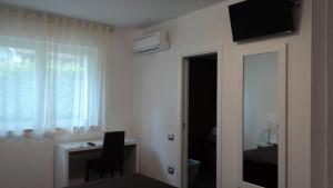 Cette chambre comprend une chambre avec un bureau et une fenêtre. dans l'établissement Il Melograno B&B, à Castellaneta Marina 33 autres photos