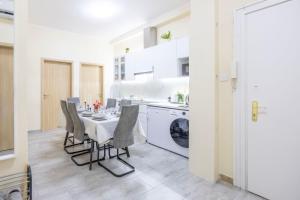 a kitchen with a table and chairs in a kitchen at Central 4BEDROOM Madách Square Apartment in Budapest