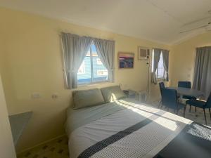 a bedroom with a bed with a window and a table at The Eulo Queen Hotel 