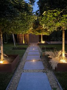 Containers aménagé au cœur des chants des grenouilles في هوتون: حديقة بها مسار مع أشجار وأضواء