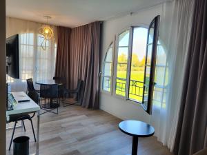a living room with a table and two windows at Adagio Serris Val d'Europe in Serris