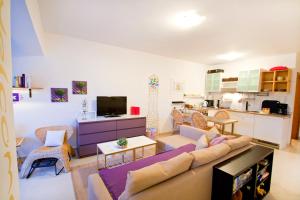 a living room with a couch and a kitchen at Adela Apartments in Dramalj