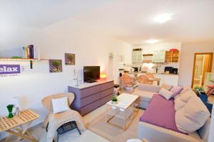 a living room with a couch and a tv at Adela Apartments in Dramalj