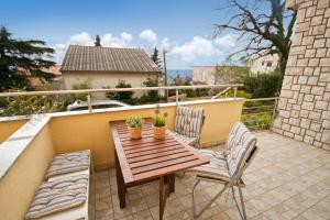 a wooden table and two chairs on a balcony at Adela Apartments in Dramalj