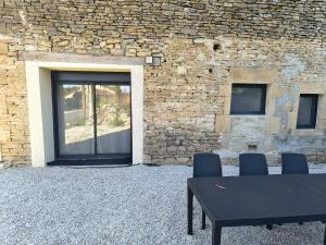 a table and chairs in front of a brick building at Gîte des castors in Harricourt