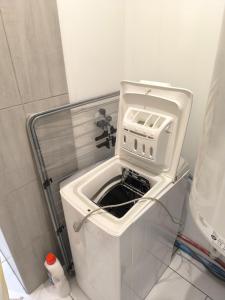 a toaster oven sitting on top of a toilet in a bathroom at Gîte des castors in Harricourt