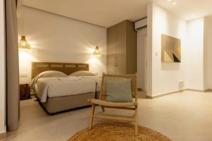a bedroom with a bed and a chair in it at Andreotis Hotel Apts in Protaras +85 photos