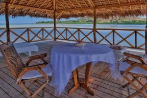 a table and chairs on a porch with the water at Villa SAHONDRA in Nosy Be +42 photos