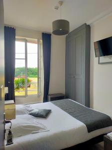 a bedroom with a large bed and a window at Logis Hotels Restaurants- Villa des Bordes in Cléry-Saint-André