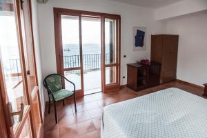 a bedroom with a bed and a balcony with the ocean at Eolcalandra Case Per Vacanza in Canneto