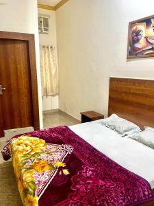 a bedroom with a bed with a red blanket on it at Shri radha rani dham in Vrindāvan +3 photos