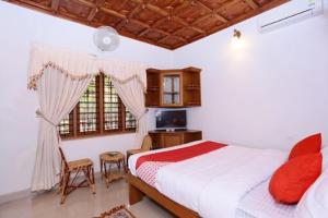 a bedroom with a bed and a desk and window at AVERA Heritage Homestay in Thekkady