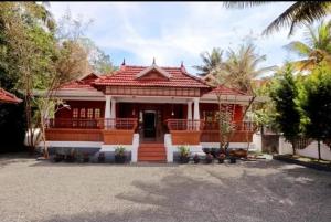 a house with a red roof at AVERA Heritage Homestay in Thekkady