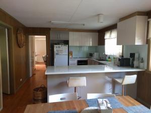 a kitchen with white cabinets and a white refrigerator at Inlet Side Eden in Inverloch