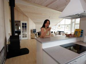 a woman standing at a counter in a kitchen at 10 person holiday home in Rødby-By Traum in Kramnitse