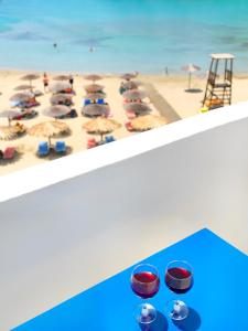 VáriにあるHotel Kameloのビーチの景色を望む客室で、椅子とパラソルが備わります。