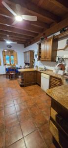 a large kitchen with wooden cabinets and a tile floor at Casa Renacimiento in Coín