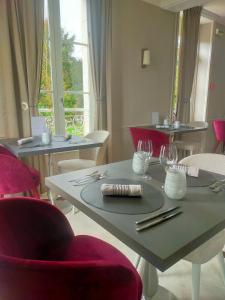 a dining room with tables and chairs with wine glasses at Logis Hotels Restaurants- Villa des Bordes in Cléry-Saint-André
