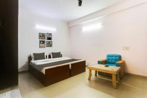 a bedroom with a bed and a blue chair at Hotel O Happy Residency in New Delhi