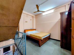 una piccola camera con letto e scala di Shravan Homestay a Kolhapur Altre 9 foto