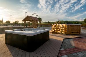 een hot tub op een terras met een tuinhuisje bij Bocor Fogadó in Kisharsány