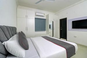 une chambre avec un lit, un canapé et une télévision dans l'établissement Super TOWNHOUSE JAHNAVI GROUP BESIDES NEXUS MALL, à Hyderabad