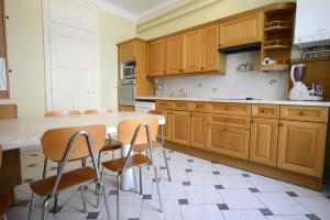 a kitchen with wooden cabinets and a table and chairs at Gites de l'Austrasie in Metz