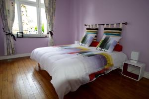 een slaapkamer met een bed met witte lakens en een raam bij Gites de l'Austrasie in Metz