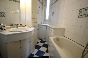 een witte badkamer met een wastafel, een bad en een wastafel bij Gites de l'Austrasie in Metz +5 foto's