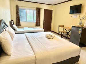 una habitación de hotel con dos camas y una mesa en Taweehome hotel, en Phra Nakhon Si Ayutthaya