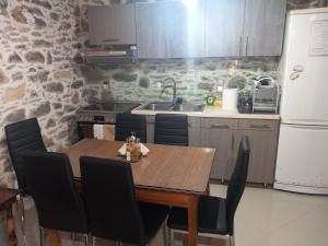 a kitchen with a wooden table with chairs and a sink at Malama's House in Káto Trítos
