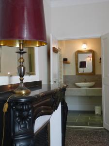 un baño con una mesa con una lámpara. en Chez Lola-Maison d'hôtes Corbières, en Durban-Corbières