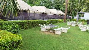 a group of white chairs and a table in a yard at Quila Camps and Resort, Burja in Alwar