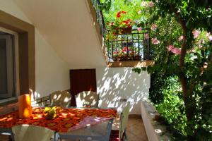 a table and chairs with flowers on a patio at Apartments Majica in Sveti Filip i Jakov
