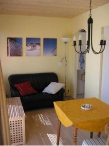 a living room with a black couch and a table at Bungalow Iris in Zinnowitz