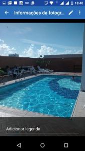 uma imagem de uma grande piscina azul em Estúdio Ibiza II em Maceió