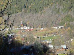 a town with a train and a bridge in a mountain at Chalet in Wiler near Ski Lift & Views in Fiesch +21 photos
