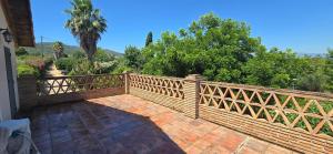 a wooden fence on a brick walkway with trees at Casa Renacimiento in Coín