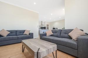 a living room with two couches and a coffee table at Terrific Townhouse 3x2 in CBD in Port Hedland
