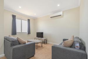 a living room with two couches and a tv at Terrific Townhouse 3x2 in CBD in Port Hedland