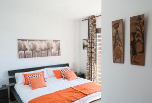 ein Schlafzimmer mit einem Bett mit orangefarbenen Kissen darauf in der Unterkunft Apartment Poris Sunrises in Poris de Abona