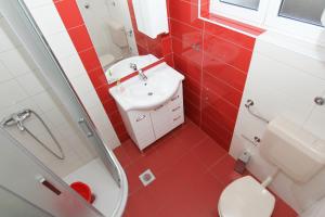 a red bathroom with a sink and a toilet at Apartments Majica in Sveti Filip i Jakov +48 photos