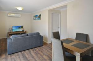 a living room with a couch and a dining room table at Pilbara Cabin Affordable 1x1 in Port Hedland