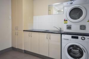 a kitchen with a washing machine and a sink at Pilbara Cabin Affordable 1x1 in Port Hedland