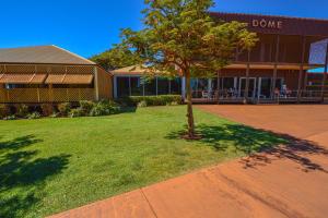 a tree in the grass in front of a building at Pilbara Cabin Affordable 1x1 in Port Hedland +2 photos