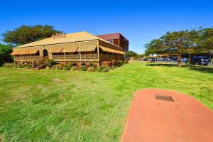 a large building with a grass field in front of it at Pilbara Cabin Affordable 1x1 in Port Hedland